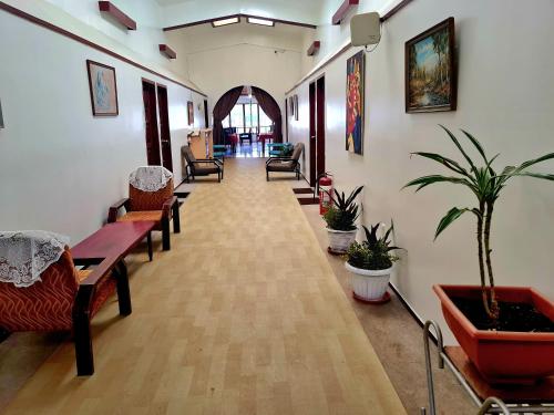 a hallway with chairs and tables and potted plants at Hotel Nuku'alofa in Nuku‘alofa