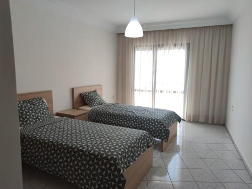 une chambre d'hôtel avec deux lits et une fenêtre dans l'établissement Appartement de standing, à Casablanca