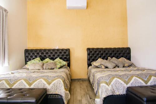 two beds sitting next to each other in a room at Quinta San Carlos Ensenada in Ensenada