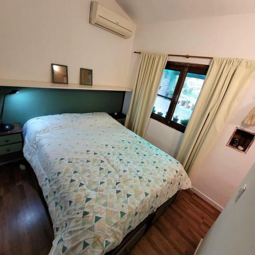 un dormitorio con una cama y una ventana en Casa Filomena, en Villa Canada del Sauce