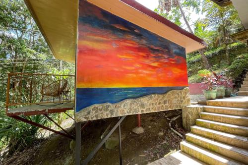 a painting on a wall next to a staircase at Restful Casa Quetzal Luxurious Rainforest Retreat in Quepos