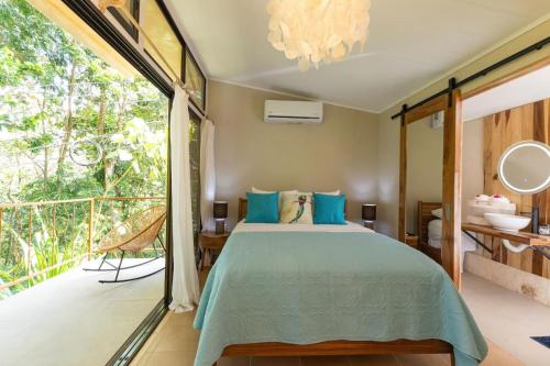 a bedroom with a bed and a balcony at Restful Casa Quetzal Luxurious Rainforest Retreat in Quepos