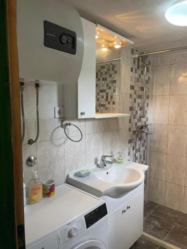 a bathroom with a sink and a washing machine at Villa Rosa, Dracevica 46a, Brac in Dračevica