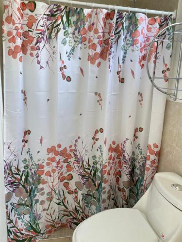 a bathroom with a shower curtain with a flower pattern at Tiny house Santa Ana in Santa Ana