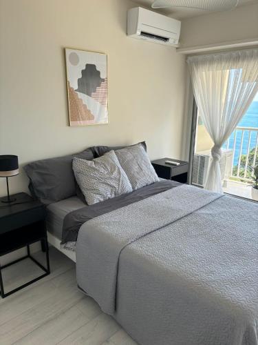 une chambre avec un lit et une grande fenêtre dans l'établissement 3 Pieces Vue Mer et acces plages, Proche Monaco, à Cap d'Ail