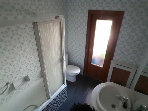 un bagno con vasca, lavandino e WC di Piso 3 habitaciones en Grado a Grado