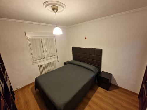 una camera da letto con un letto in una stanza con una finestra di Piso 3 habitaciones en Grado a Grado