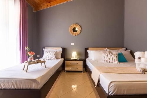 a bedroom with two beds and a mirror on the wall at Potam'Sea Bliss 33- Beach Front, Sun Beds & Parking in Himare