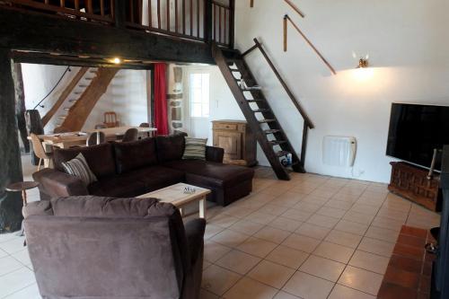 a living room with a couch and a tv at Gîte de La Guinchère in Saint-Georges-de-Reintembault