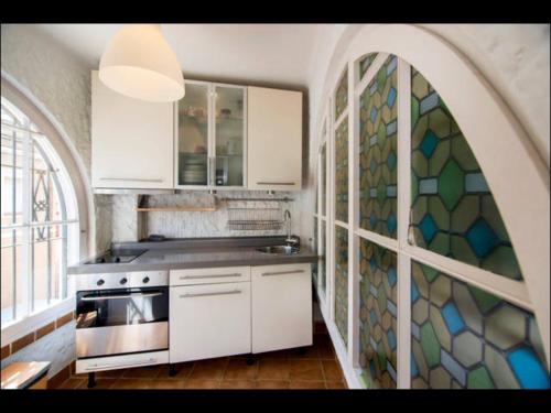 una cocina con armarios blancos y una pared de mosaico en Holiday home Anexa, en Masnou