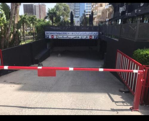 een rood-witte poort met een bord erop bij Appart malabata in Tanger