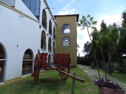 a red bench in front of a building at HOTEL XIADANI Restaurante, Temazcal & Spa in Tlaxcala de Xicohténcatl
