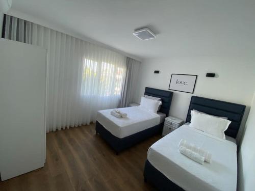 a bedroom with two beds and a sign that reads love at Villa Deja Blue in Karaburun