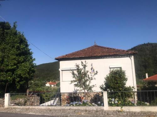 a white house with a fence in front of it at Casa da Aldeia in Figueiró dos Vinhos