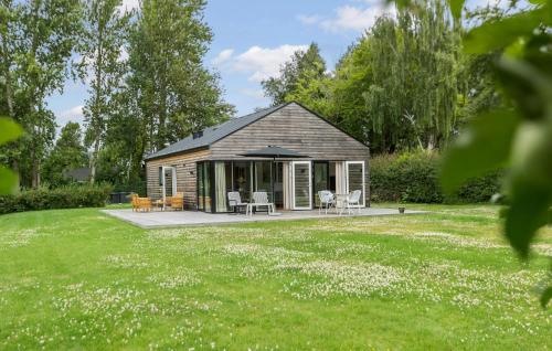 a log cabin with chairs and tables in a yard at 3 Bedroom Nice Home In Jægerspris in Jægerspris