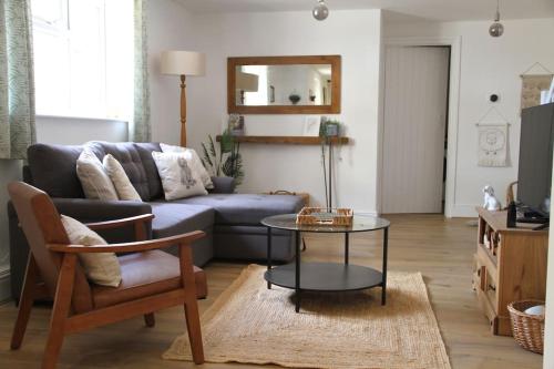a living room with a couch and a table at Peaceful Cotswolds Cottage - Stow-on-the-Wold, Owl Cottage in Wyck Rissington