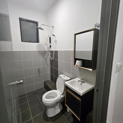a bathroom with a toilet and a sink and a mirror at B3A-5 Suites in Papar