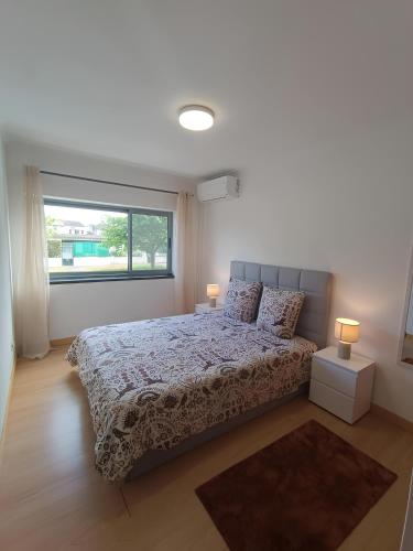 a bedroom with a bed with two lamps and a window at Ponta Delgada 3 Bedroom Apartment in Ponta Delgada