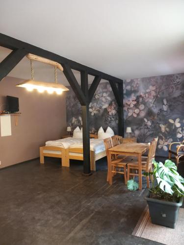 ein Schlafzimmer mit einem Bett und einem Tisch und Stühlen in der Unterkunft Pension Steigerhof Johanngeorgenstadt in Johanngeorgenstadt