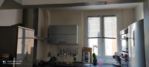 une cuisine avec une grande fenêtre et un comptoir de cuisine dans l'établissement Jeux olympiques Paris 2024, à Rouen