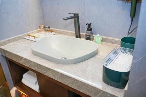 a white sink on a counter in a bathroom at Nost algia S Hotel Hangzhou West Lake & Lingyin Temple 时光漫步S酒店杭州西湖店 Free laundry service, Free fresh ground coffee in Hangzhou