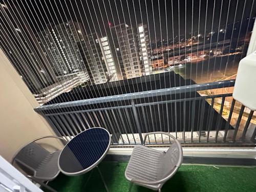 a window with two chairs and a view of a city at Lylinz sierra heights in Pasir Gudang