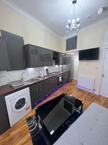 a kitchen with a washer and a stove in it at Glasgow South 2 Bedroom Apartment in Glasgow