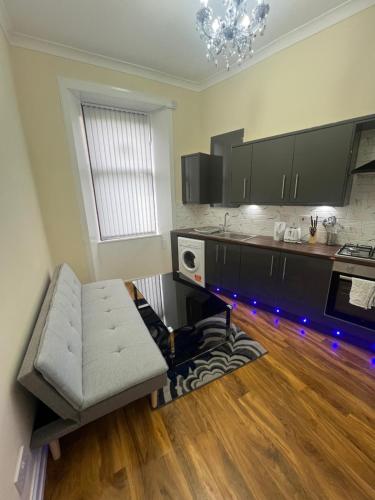 a living room with a couch and a kitchen at Glasgow South 2 Bedroom Apartment in Glasgow