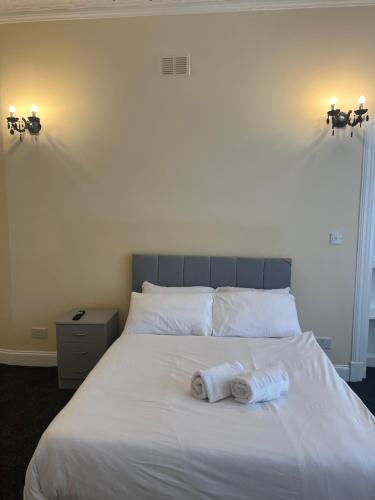 a bedroom with a bed with two towels on it at Glasgow South 2 Bedroom Apartment in Glasgow