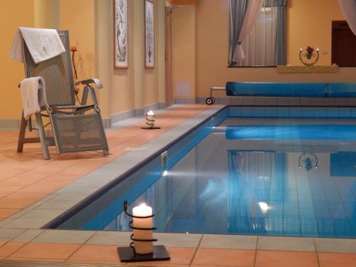 a swimming pool with a chair next to it at Hotel Julianin dvor in Habovka