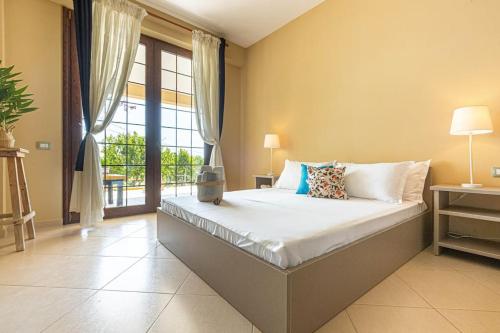 a bedroom with a bed and a large window at Color Villa - South Paradise 5 in Himare