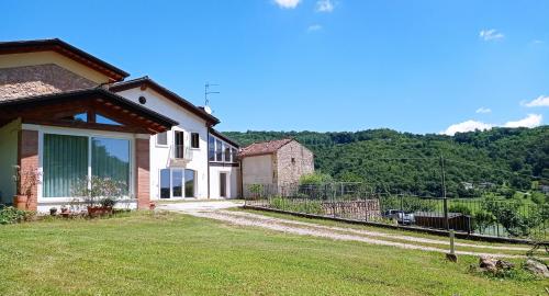 a house with a green yard with a view at Agriturismo Casa Bregalda in Castelgomberto