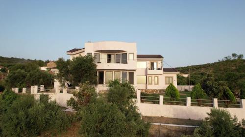 a house on a hill with a fence at Zografos Studios Zacharo Zakharo in Zakharo