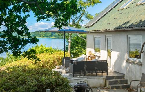 a house with a patio with an umbrella at Gorgeous Home In Fredericia With Wifi in Fredericia