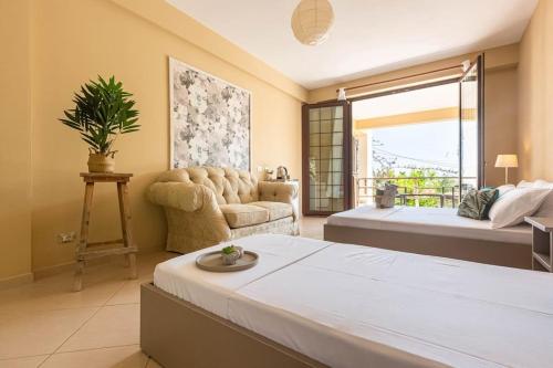 a bedroom with a bed and a couch and a window at Color Villa - South Paradise 6 in Himare