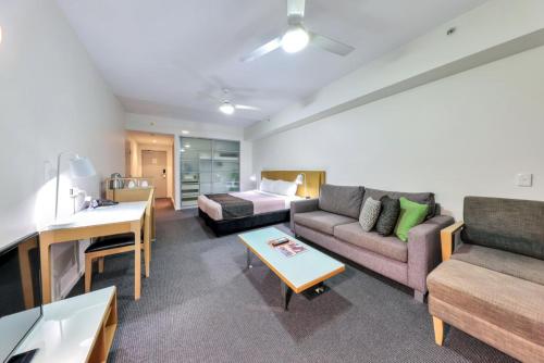 a living room with a couch and a bed at Sensation Sunsets Seaviews I Mantra' Central CBD Apartment in Darwin