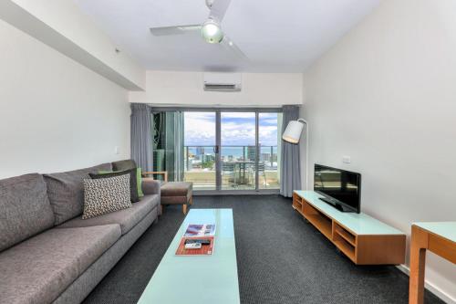 a living room with a couch and a table at Sensation Sunsets Seaviews I Mantra' Central CBD Apartment in Darwin
