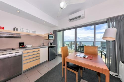a kitchen and dining room with a table and chairs at Sensation Sunsets Seaviews I Mantra' Central CBD Apartment in Darwin