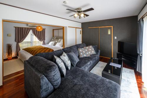 a living room with a couch and a bed at Ocean View Terrace BISE 1F in Motobu