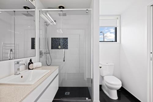 a white bathroom with a sink and a toilet at Modern, Spacious Home on Popular Muricata Av - Enjoy Beach, Surf & Sun in Mount Maunganui