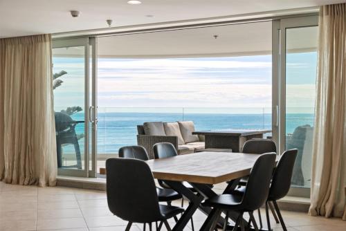 a dining room with a view of the ocean at Oceanside Bliss - Absolute Beachfront - Uninterrupted Ocean Views with Pool in Mount Maunganui
