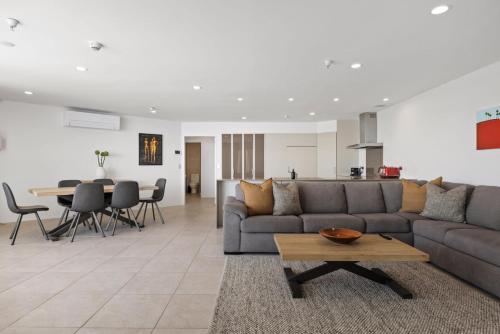 a living room with a couch and a table at Oceanside Bliss - Absolute Beachfront - Uninterrupted Ocean Views with Pool in Mount Maunganui