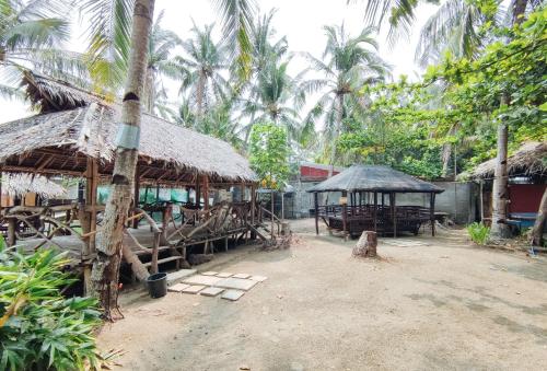 a village with a building with a straw roof at Iloilo Paraw Beach Resort in Iloilo City