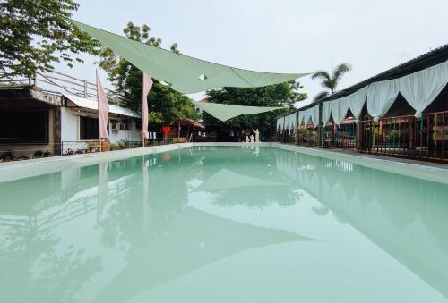 a swimming pool with blue water in front of a building at Iloilo Paraw Beach Resort in Iloilo City