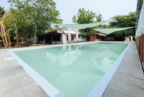 a swimming pool with a canopy over it at Iloilo Paraw Beach Resort in Iloilo City