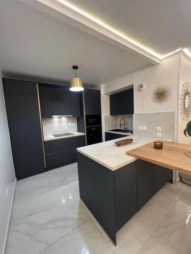 une cuisine avec des armoires noires et un comptoir en bois dans l'établissement Appartement de Luxe, à Villepinte