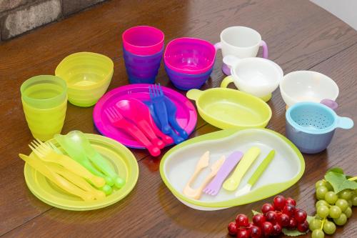 a table with colorful plates and cups and grapes at アンティークス岐阜駅東 in Gifu