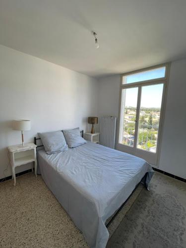 une chambre blanche avec un lit et une fenêtre dans l'établissement Blue Paradise, à La Ciotat