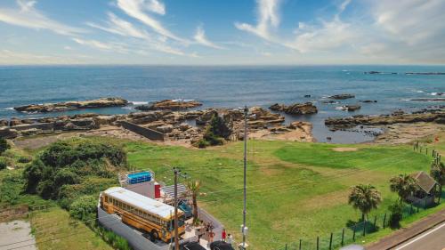 Un autobús escolar está estacionado junto al océano. en Hotel Ocean BUS Shirahama, en Shioura