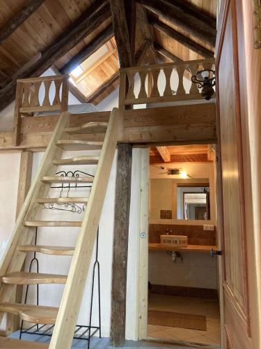 une échelle menant à une mezzanine dans une maison dans l'établissement Gîte Le Moulin papillon, à LʼArgentière-la-Bessée